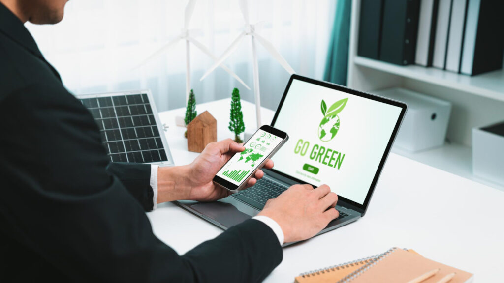 Person using a laptop and smartphone for eco-friendly work.